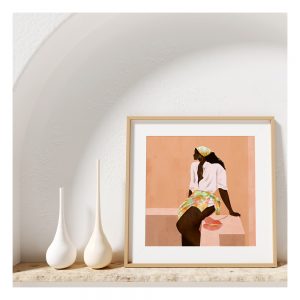 'A Short Wait' print framed next to two white vases