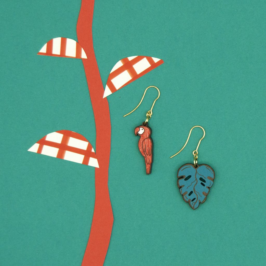 A pair of earrings set against a green background.