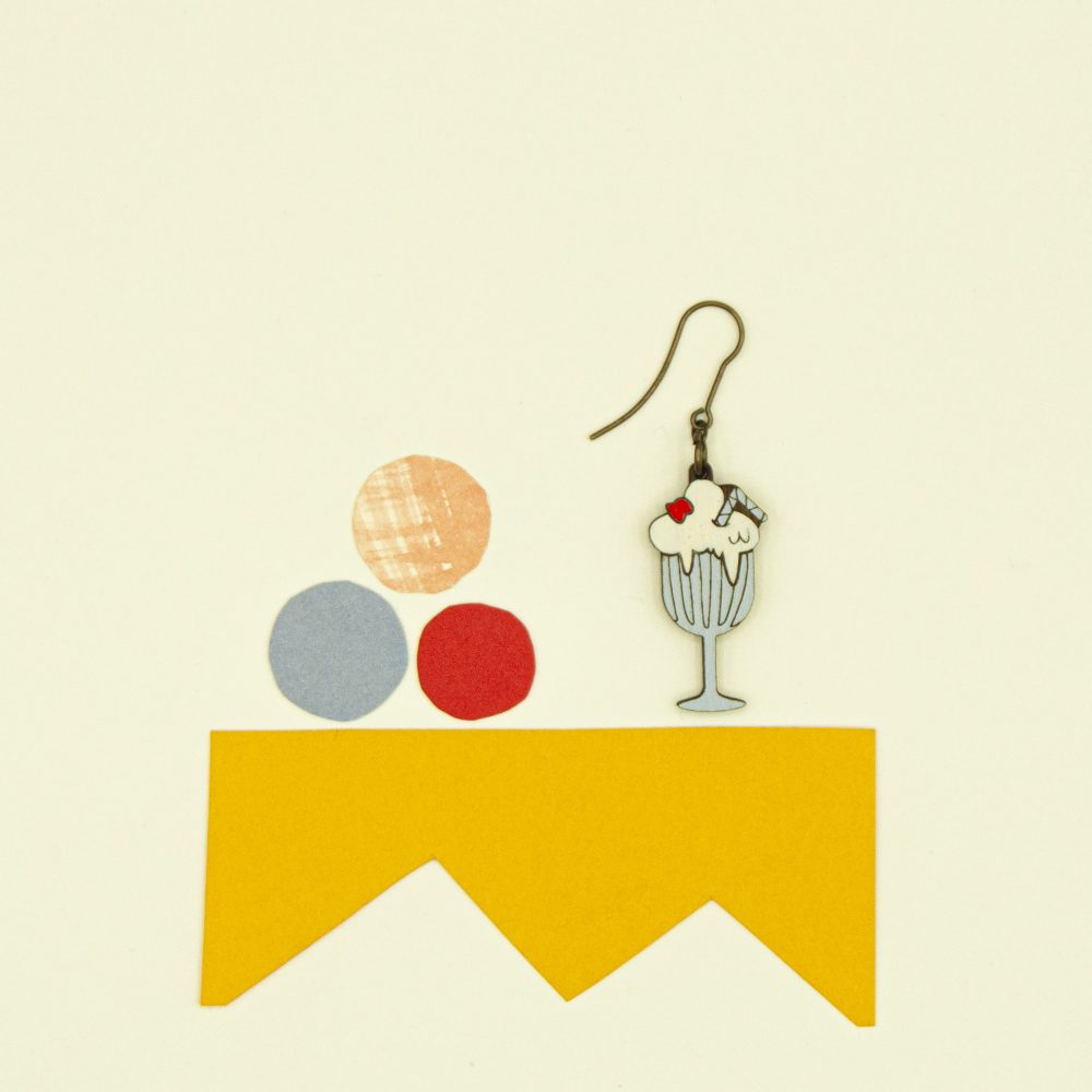 Lasercut wood milkshake earrings against a yellow background.