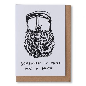 White greetings card with a black and white illustration of a man's face with a large beard. Text beneath the illustration reads "Somewhere in there is a mouth".. Comes with a brown Kraft envelope.