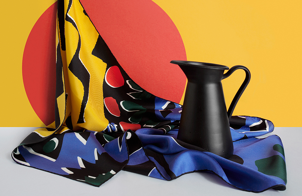 Blue black and yellow patterned silk scarf with a black jug