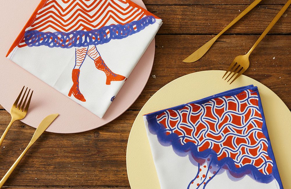 A set of napkins featured red and blue patterned skirts, with booted legs emerging from the hems.