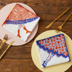 A set of napkins featured red and blue patterned skirts, with booted legs emerging from the hems.