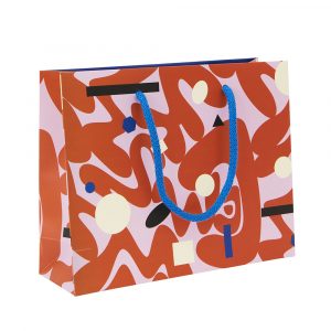 A patterned gift bag featuring rounded abstract shapes in red on a lilac background.