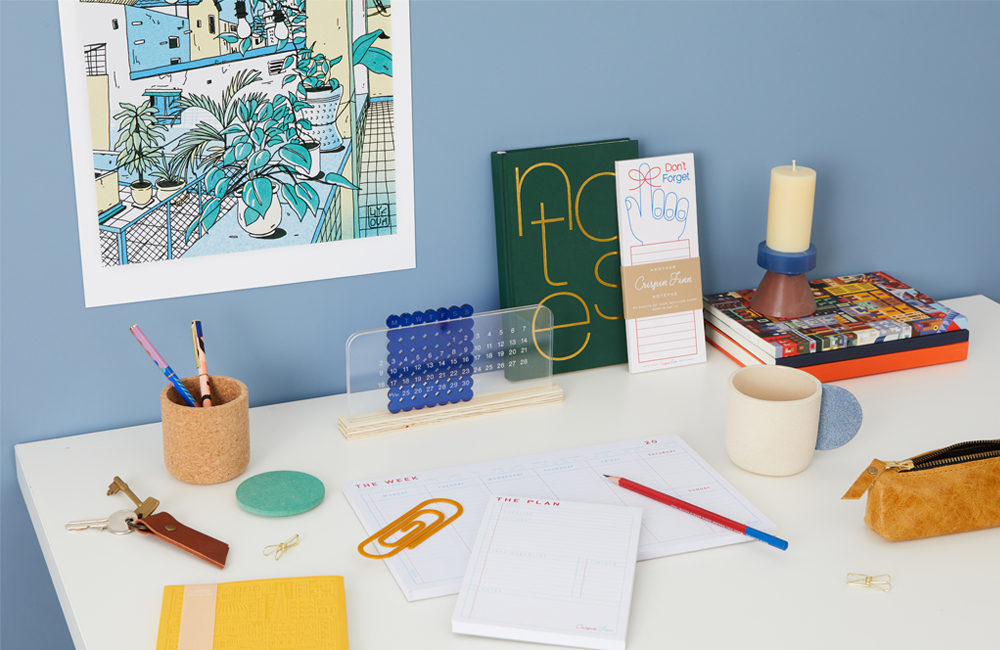 A desk set up with different weekly and day planers, as well as pens and various stationary.