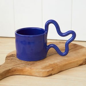 A ceramic bug with a wiggly handle in a deep blue colour