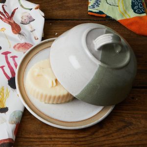 butter candle inside a green ceramic butter dish