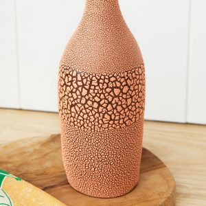 Close up of a coral Ceramic Oil bottle with crackling effect finish