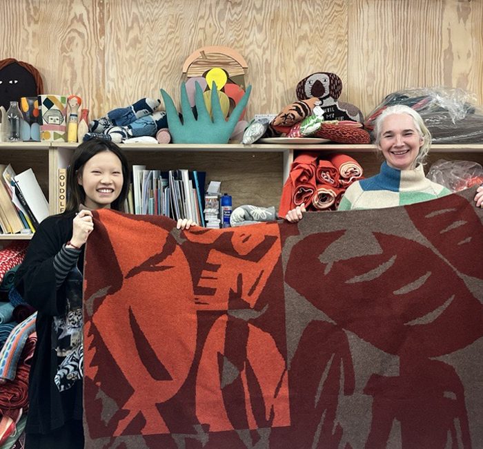 Doudou Huang and Donna Wilson holding red version of Breadworld blanket together