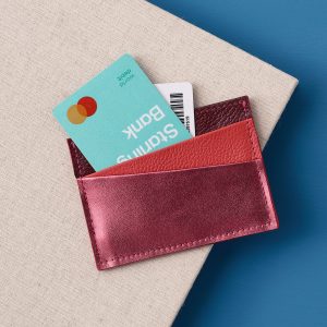 A card holder in three different shades of red. The front slot is in a metallic cherry red leather.