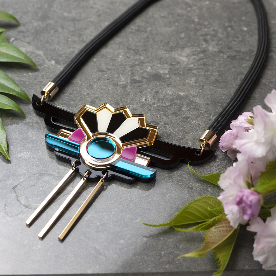 Black acrylic necklace with gold, pink and teal coloured detailing
