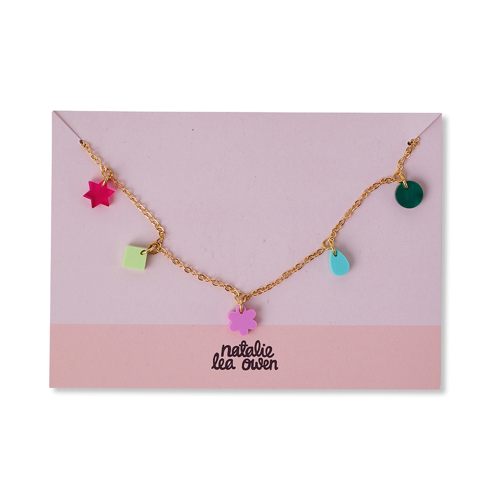 Gold charm necklace by jewellery designer Natalie Lea Owen. Multi-coloured, small charms in abstract shapes. The necklace is presented on a branded pink card.