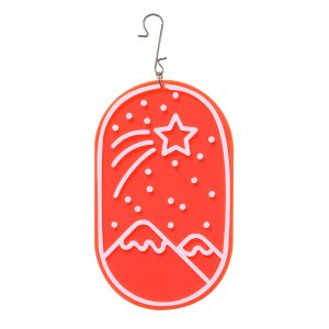 A red acrylic Christmas decoration with a shooting stair and mountain design in white.
