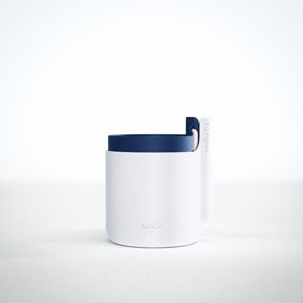A 3D printed plastic self watering plant pot. The main body is a marbled grey colours, whilst the insert is a dark navy blue. The pot features a logo of a stylised smiling face with sunglasses.