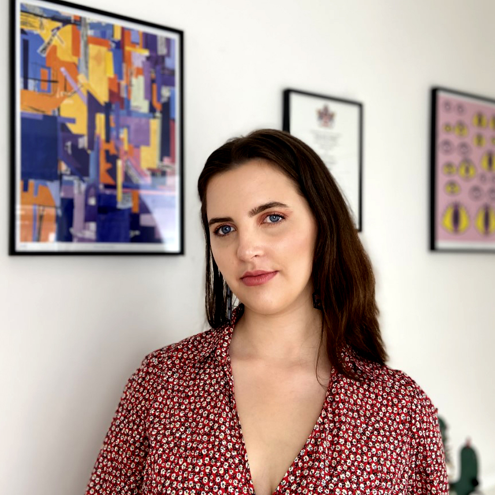 Paige Eden alongside her print on a wall