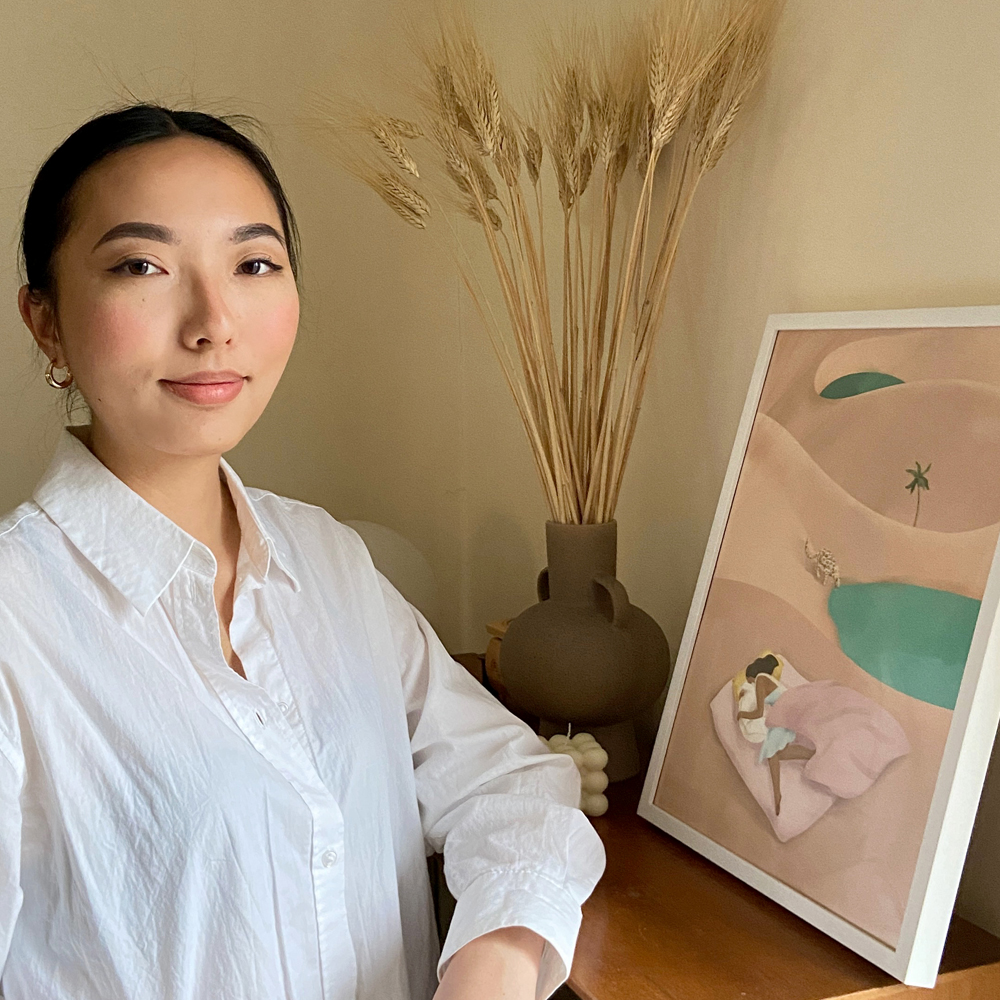 Sue Sun next to a framed image of her work